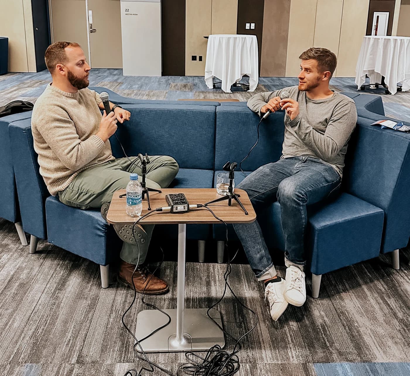 Jay recording an interview in person, two microphones on a small table